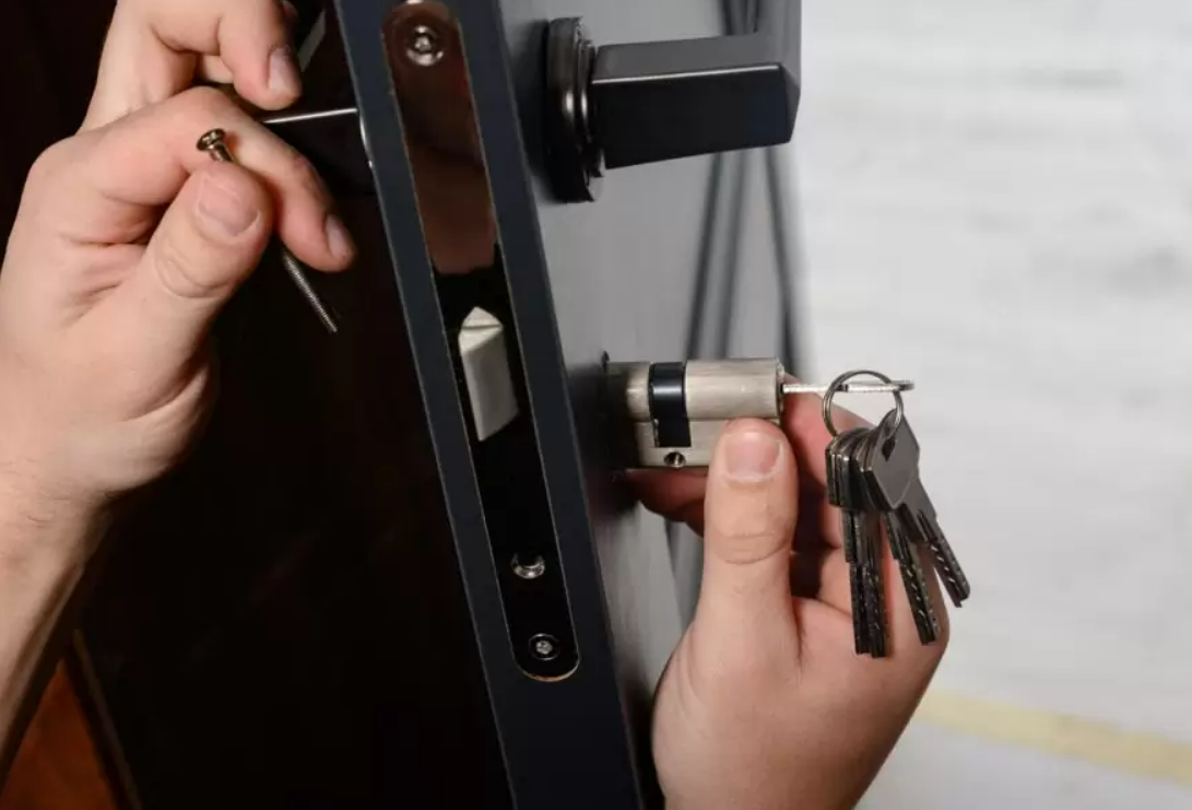 Alt Text: "Professional locksmith changing a residential house lock in Ohio, ensuring home security and safety."